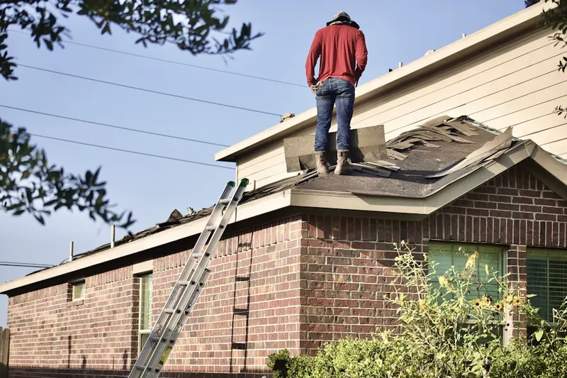 Professional roofer working on a residential roof in Elm